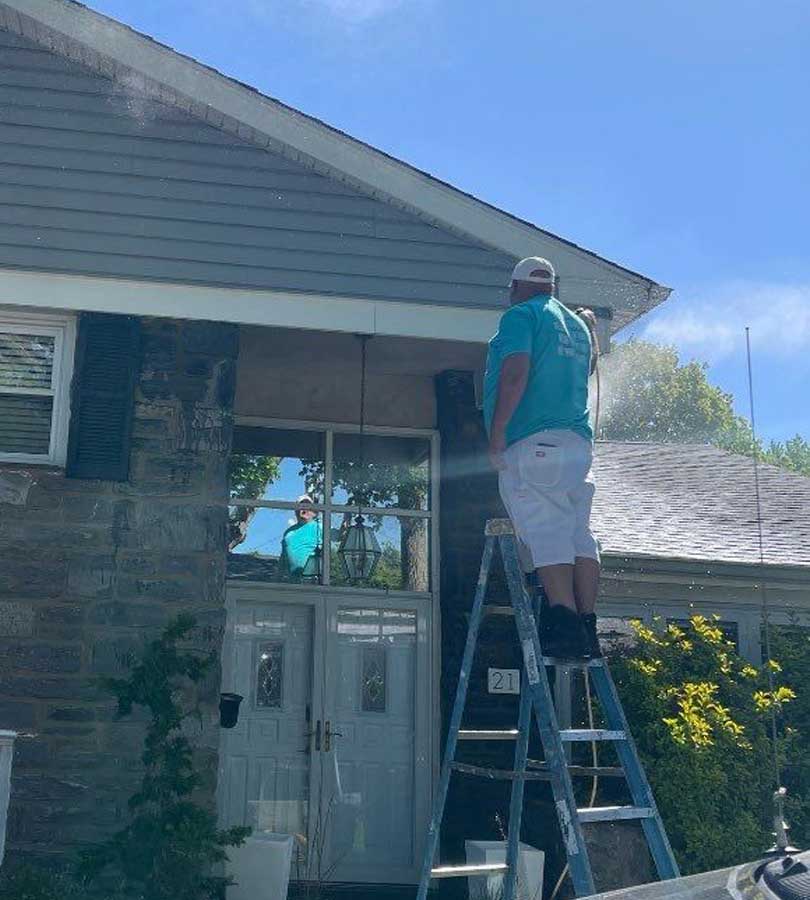 Painter painting a house outdoors in Philadelphia